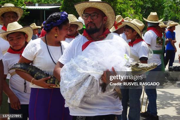 Villagers walk a spectacled caiman called "La Niña Princesa" , dressed as a bride, before being married to the Mayor in San Pedro Huamelula, Oaxaca...