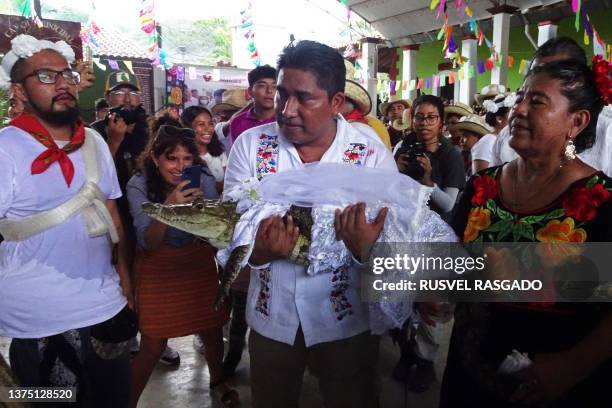 Victor Hugo Sosa, Mayor of San Pedro Huamelula, holds a spectacled caiman called "La Niña Princesa" before marrying her in San Pedro Huamelula,...