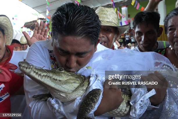 Victor Hugo Sosa, Mayor of San Pedro Huamelula, kisses a spectacled caiman called "La Niña Princesa" before marrying her in San Pedro Huamelula,...