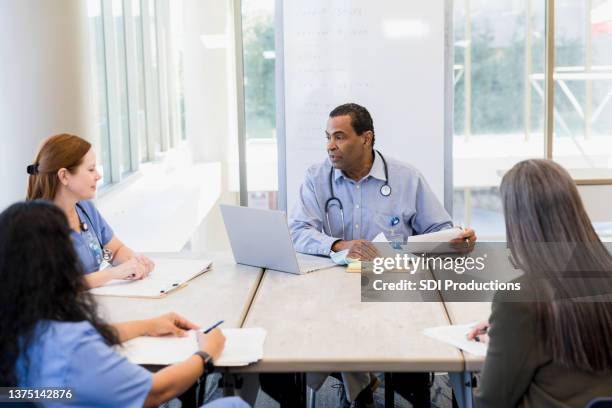 high angle view hospital staff meeting - healthcare paperwork stock pictures, royalty-free photos & images