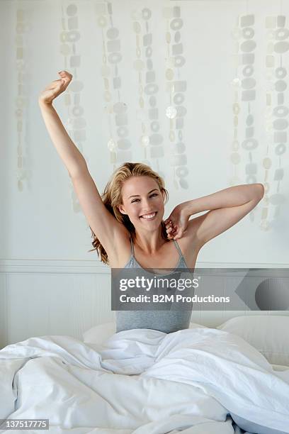 young woman stretching on bed - morning bed stretch stock pictures, royalty-free photos & images