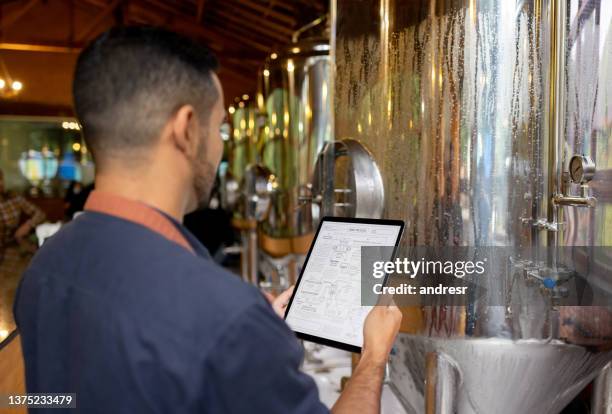 brewmaster controlling the production line at a brewery - craft brewery stock pictures, royalty-free photos & images