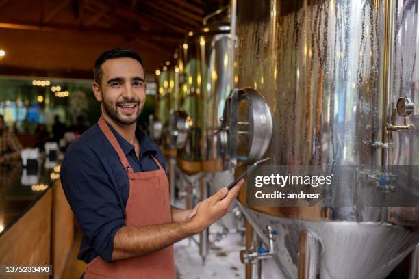 brewer controlling the production line at his brewery - brewmaster stockfoto's en -beelden