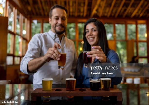 happy couple trying some beers while taking a tour at a brewery - craft beer festival stock pictures, royalty-free photos & images