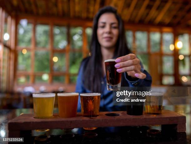 woman trying some beers while taking a tour at a brewery - craft beer festival stock pictures, royalty-free photos & images