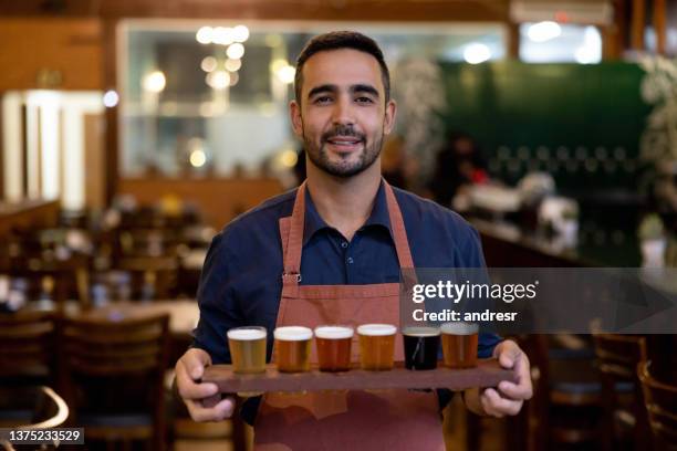 brewmaster holding a sampler of beers at his brewery - craft beer 個照片及圖片檔