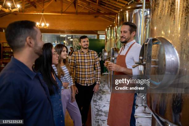 braumeister unterrichtet eine gruppe von menschen über bier in einer brauerei - destillation stock-fotos und bilder