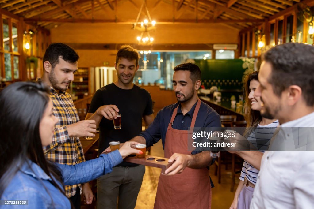 Group of people drinking samples of beer after taking a tour at a brewery