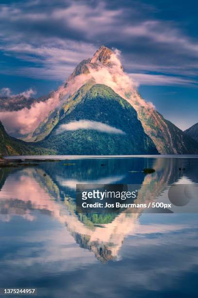 mitre peak reflection,scenic view of lake by mountain against sky,southland,new zealand - milford sound stock pictures, royalty-free photos & images