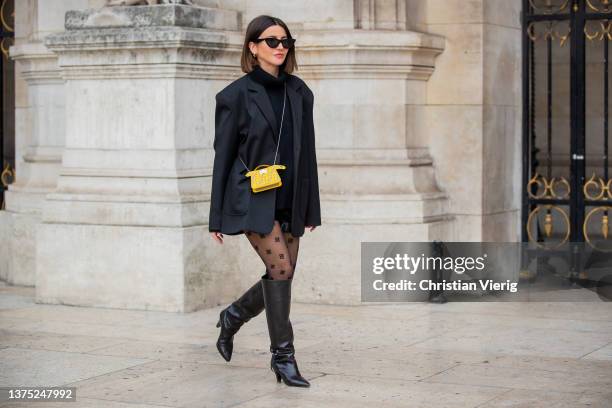 Alexandra Pereira seen wearing micro yellow Fendi bag, black dress, blazer, sheer tights with print, black knee high b outside Nanushka during Paris...