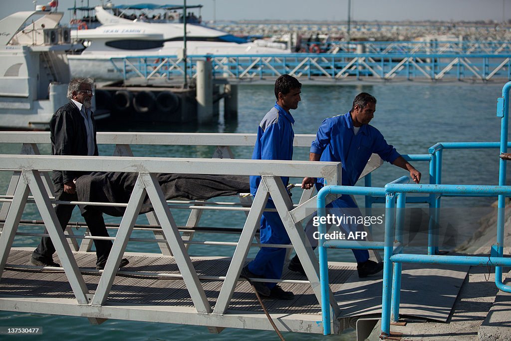 Iranians take the body of a capsized boa