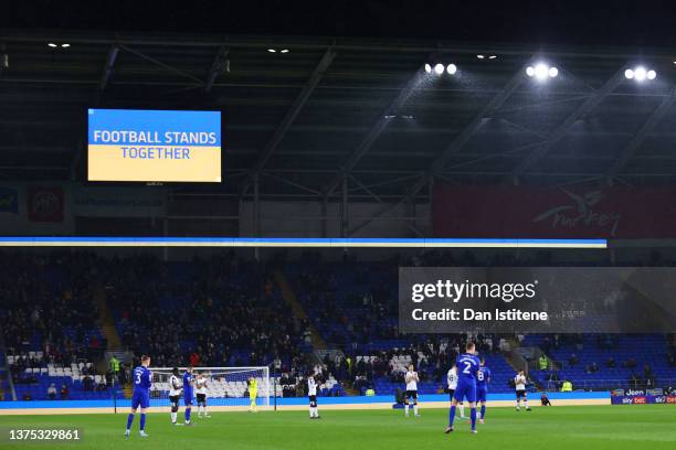 The players applaud as one of the screens displays a message of solidarity with Ukraine during the Sky Bet Championship match between Cardiff City...