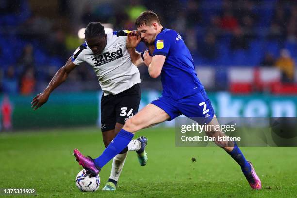 Festy Ebosele of Derby County battles for the ball with Mark McGuinness of Cardiff City during the Sky Bet Championship match between Cardiff City...