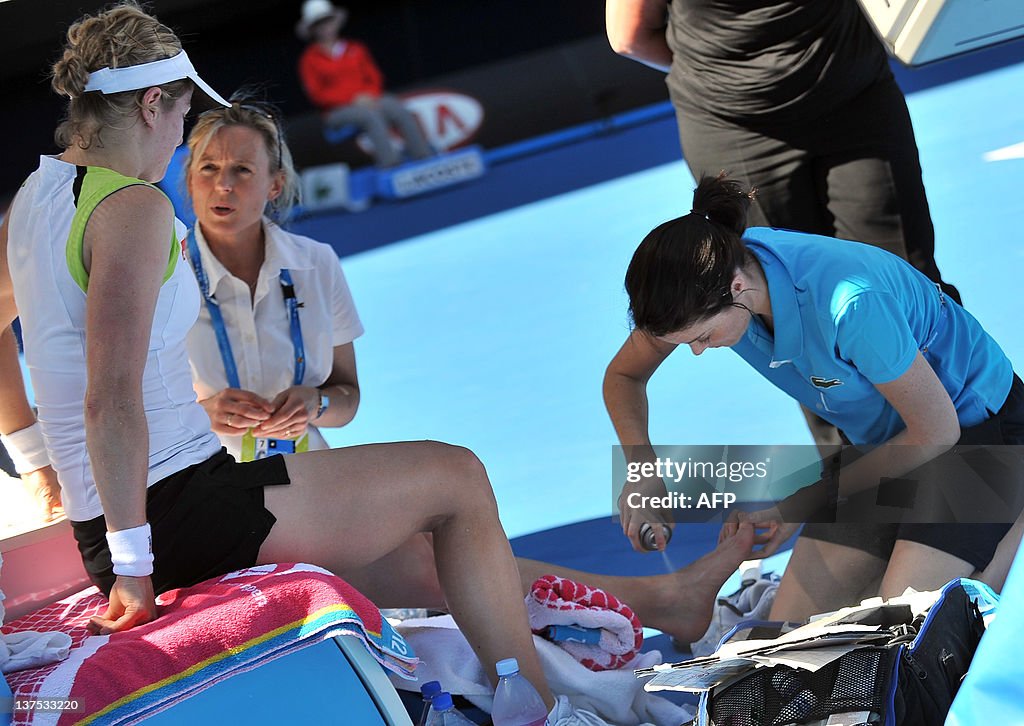 A trainer (R) works on the ankle of Kim