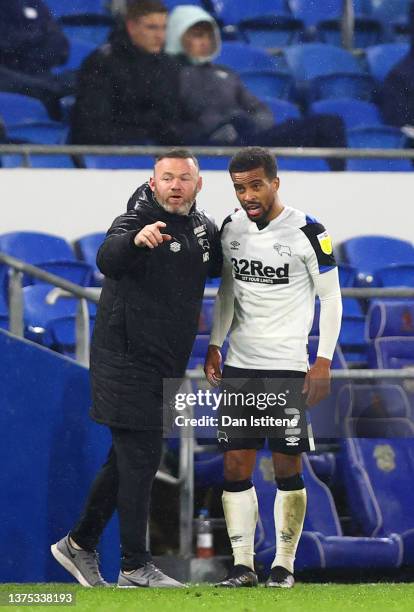 Wayne Rooney, manager of Derby County speaks with Nathan Byrne on the touchline during the Sky Bet Championship match between Cardiff City and Derby...