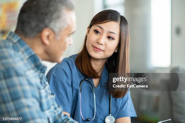 gespräch mit einer homecare-krankenschwester - pflegedienst blau stock-fotos und bilder