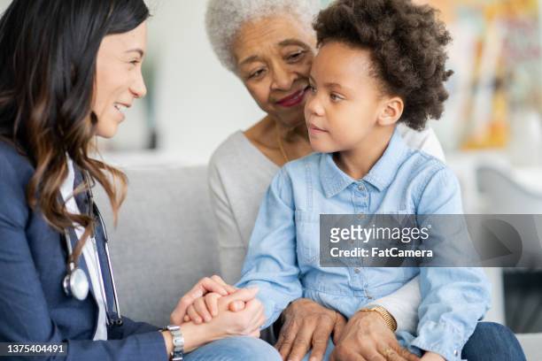 seduto con la nonna durante una visita di assistenza domiciliare - child mental health wellness foto e immagini stock