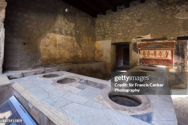 roman restaurant aka "thermopolium" (roman restaurant, inn or food and drink stall) in pompei, campania, italy, a unesco heritage site - ancient rome food stock pictures, royalty-free photos & images