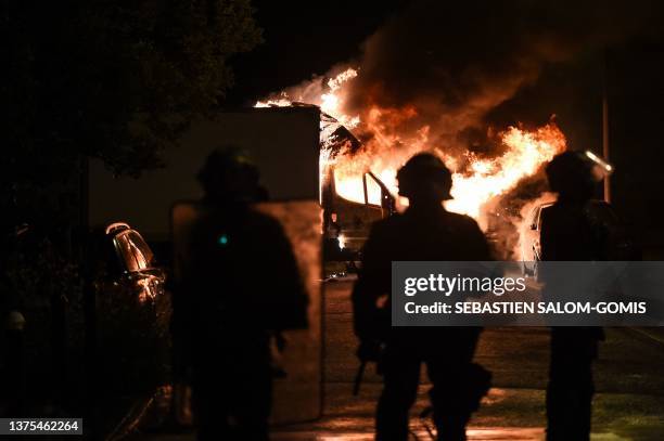 French anti riot police officers watch a truck burn in Nantes, western France on early July 1 four days after a 17-year-old man was killed by police...