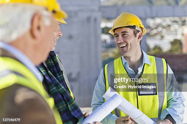 businessman and workers talking on site - construction meeting helmet stock pictures, royalty-free photos & images