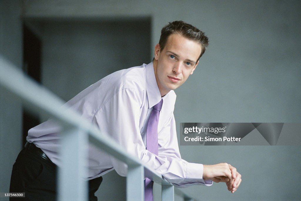 Businessman leaning on banister