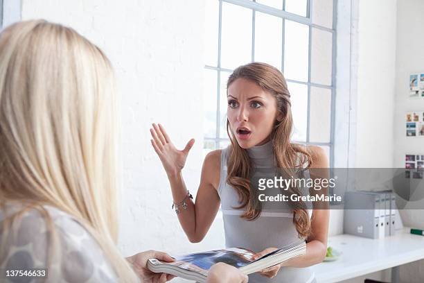 businesswomen arguing in office - diverbio foto e immagini stock
