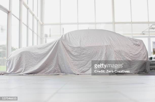 car covered in cloth in garage - covered car photos et images de collection