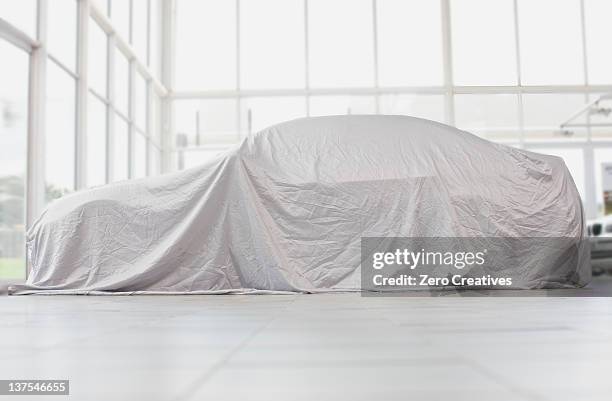 car covered in cloth in garage - tarpaulin stock pictures, royalty-free photos & images