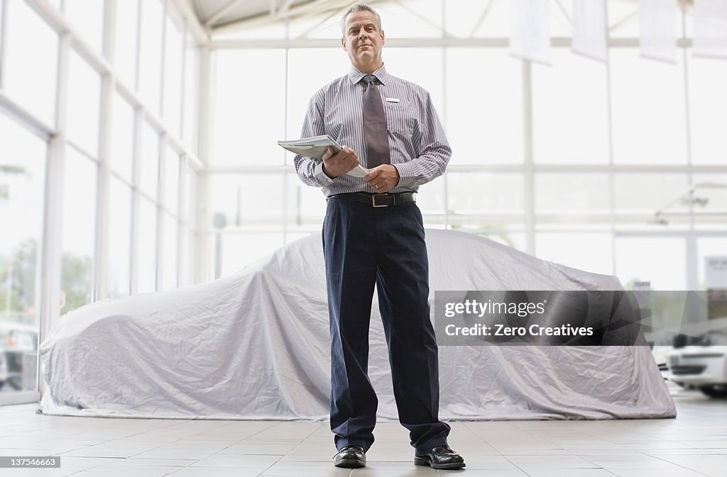 Car salesman standing in showroom