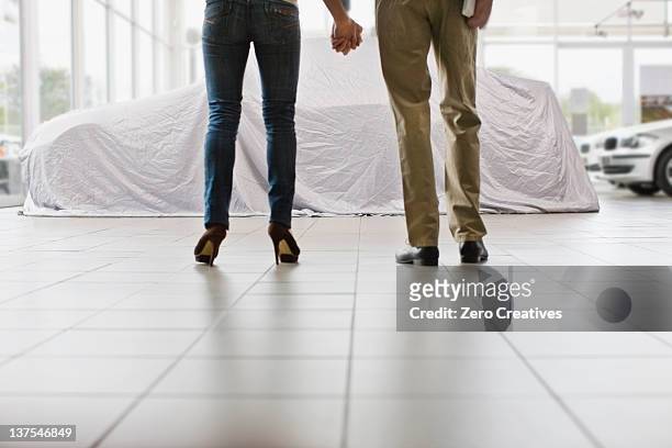 couple admiring new car under cloth - mystery car stock pictures, royalty-free photos & images