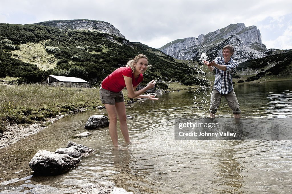 Couple playing in rocky lake