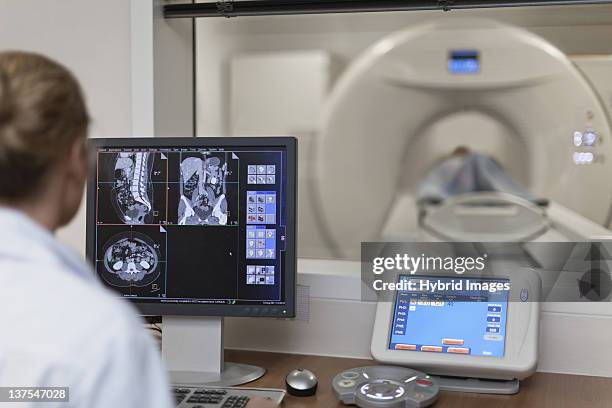 doctor operating ct scanner in hospital - mri machine stockfoto's en -beelden