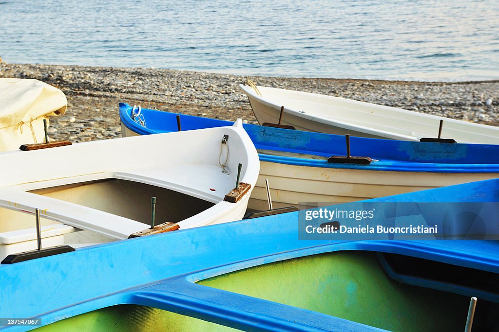 Empty canoes on rocky beach