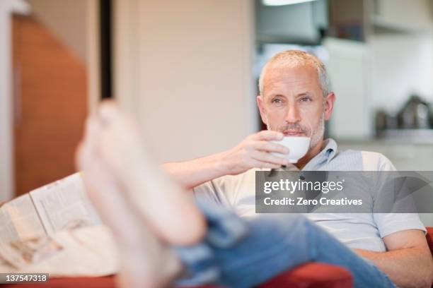 man drinking coffee in armchair - feet up stock pictures, royalty-free photos & images