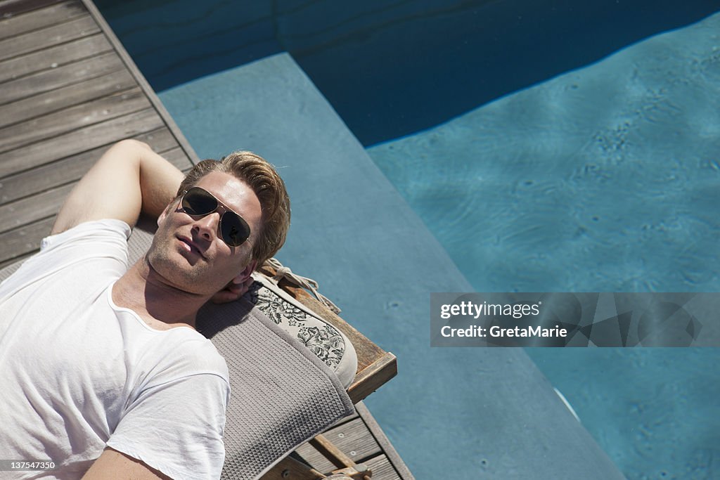 Man relaxing by swimming pool