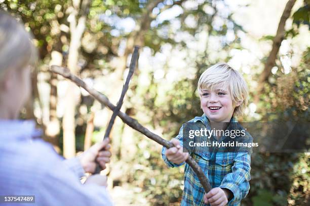 mother and son playing with sticks - girls wrestling stock pictures, royalty-free photos & images