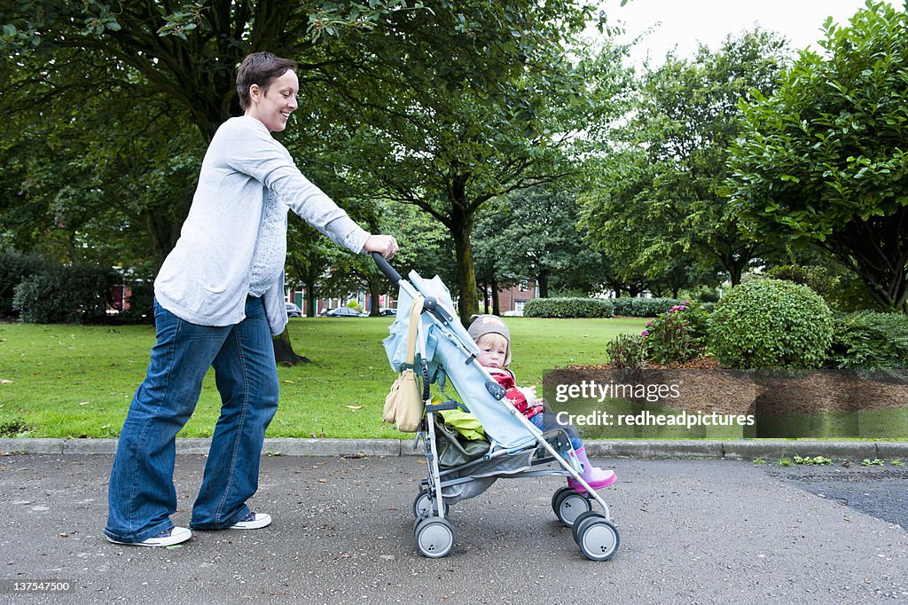 Mother pushing daughter in stroller