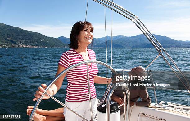 older couple relaxing on sailboat - driving barefoot stock pictures, royalty-free photos & images