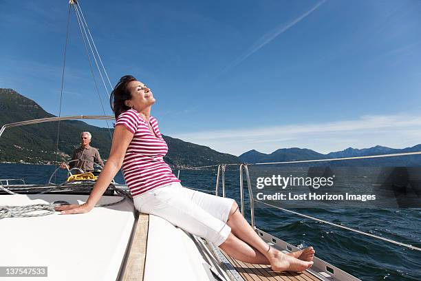 older couple relaxing on sailboat - blue sailboat stock pictures, royalty-free photos & images