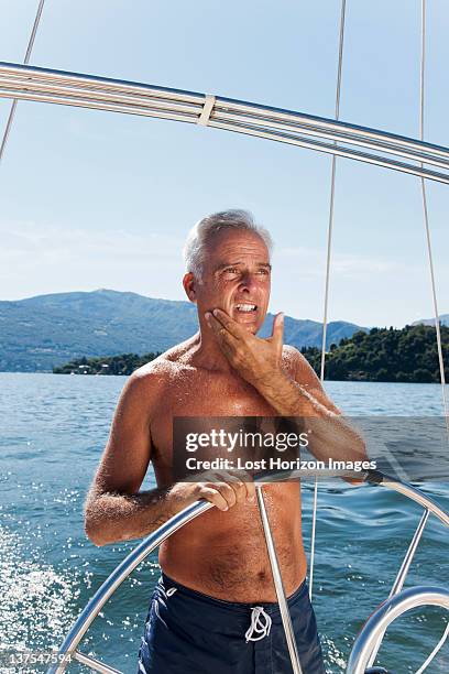 older man sailing on lake - boat helm stock pictures, royalty-free photos & images
