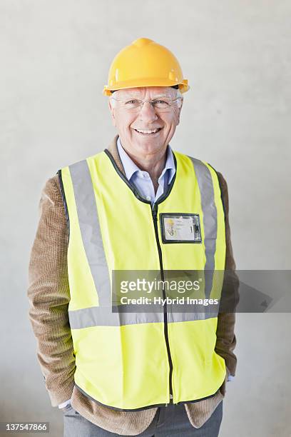 smiling businessman wearing hard hat - reflexkläder bildbanksfoton och bilder
