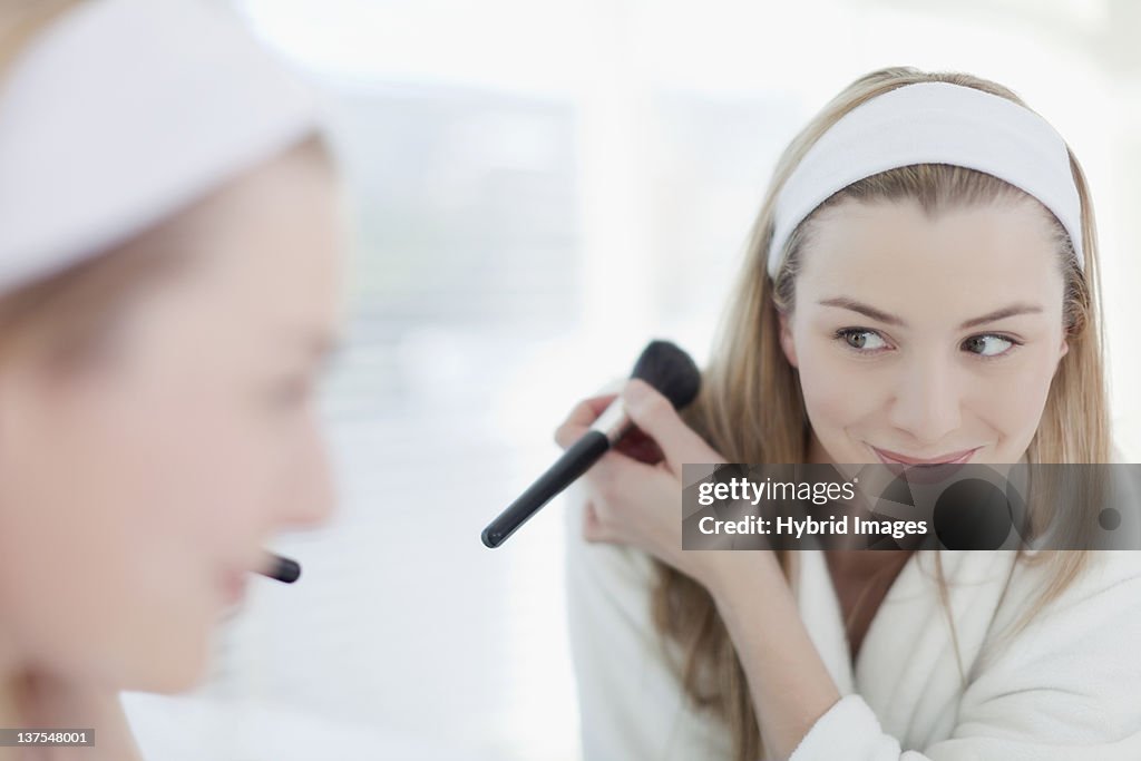 Smiling woman applying makeup