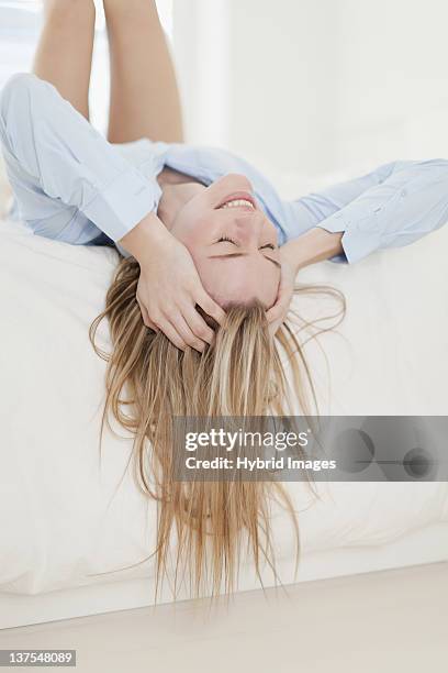 gestresste frau leg dich auf bett - auf-den-kopf-gestellt stock-fotos und bilder