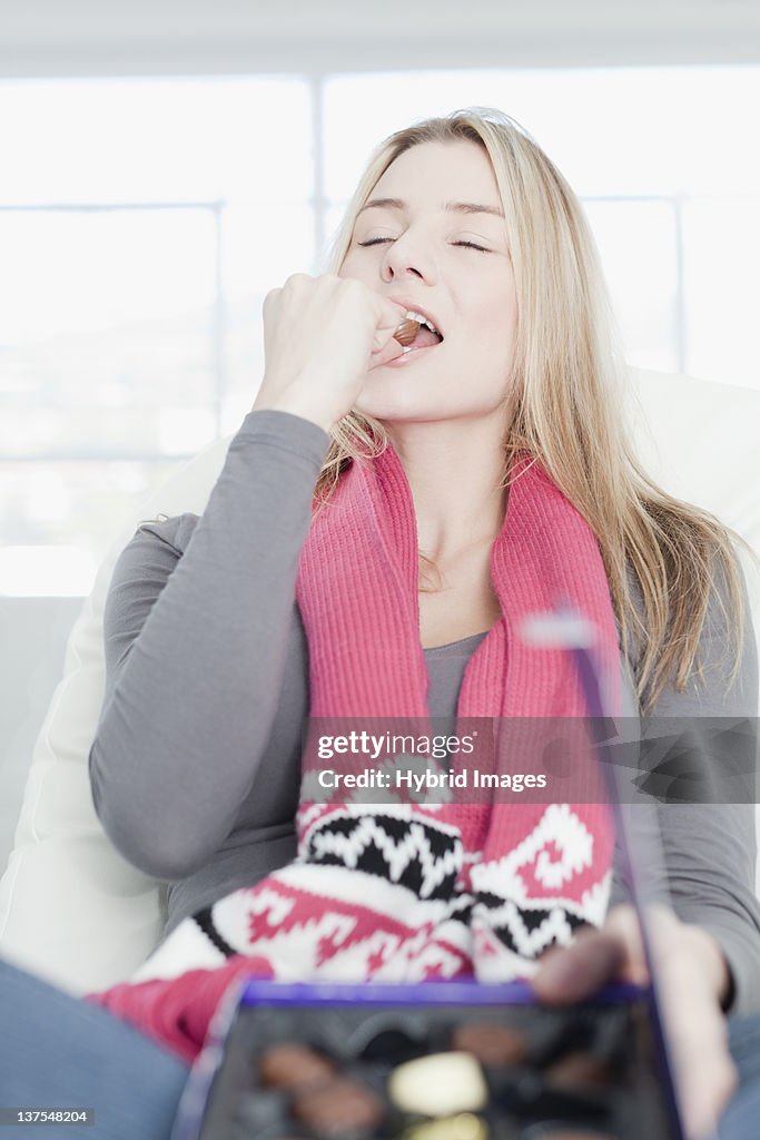 Teenage girl eating box of chocolates