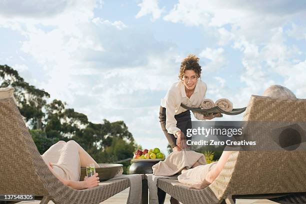 waitress serving couple relaxing by pool - poolside stock pictures, royalty-free photos & images