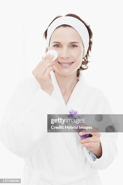 woman in bathrobe cleansing her face - removing make up stock pictures, royalty-free photos & images