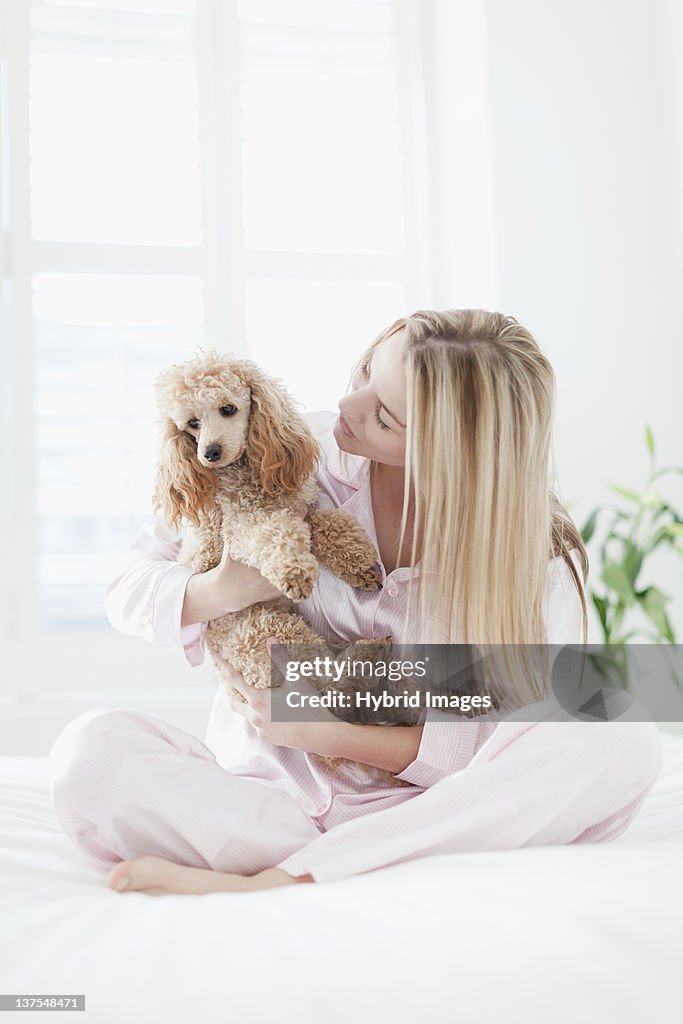 Frau spielen mit Hund im Bett