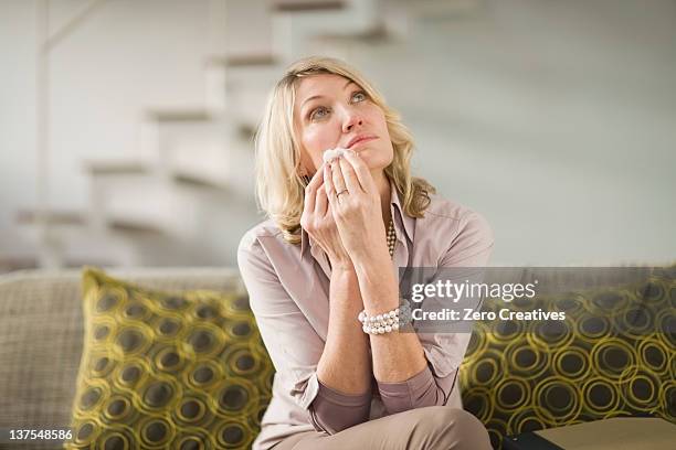 woman wiping tears from cheeks - crying woman stockfoto's en -beelden