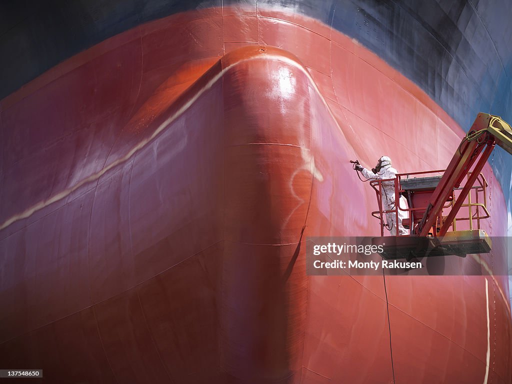 Spray painting underside of ship in dry dock