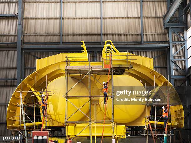 engineers with mid water arch flotation device in shipping yard - scheepsbouwer stockfoto's en -beelden